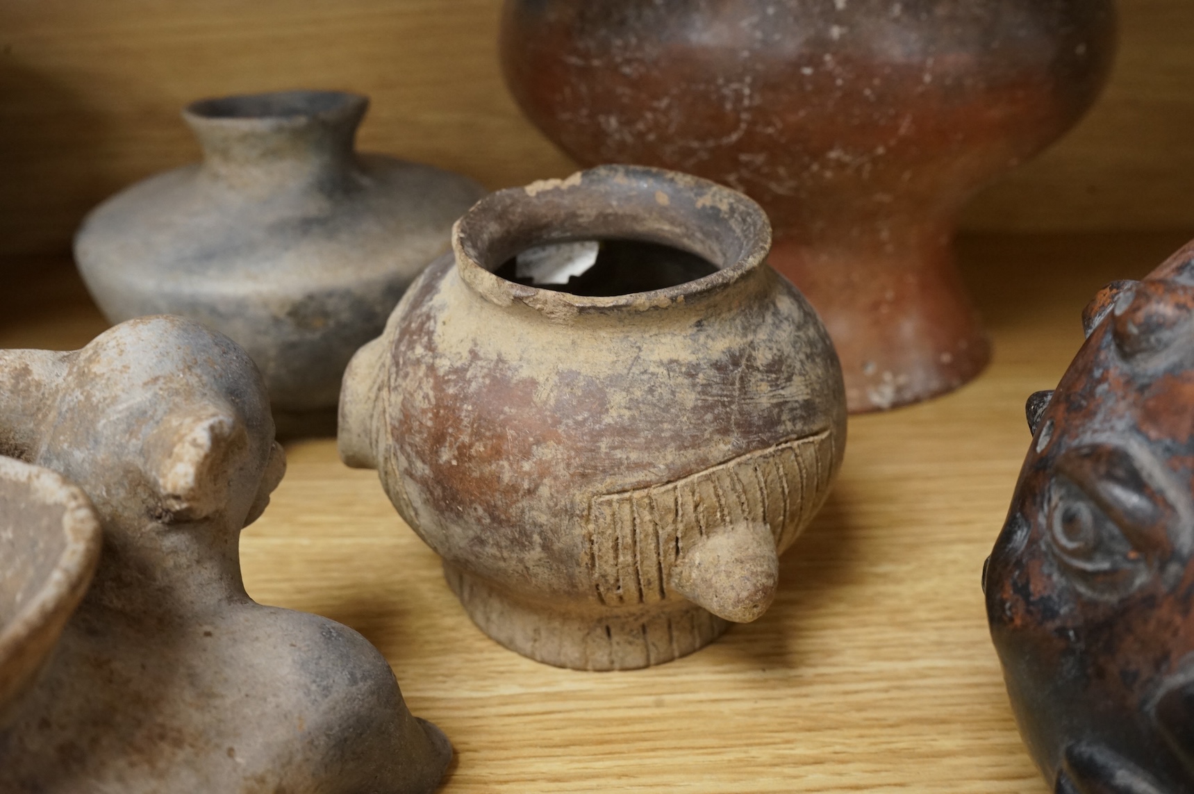 A collection of various South American vessels some in the form of grotesque heads, largest 24cm wide